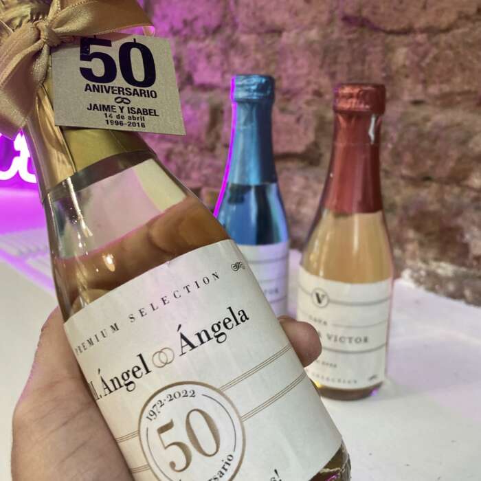 Vino espumoso con etiqueta personalizada para los novios y lazo